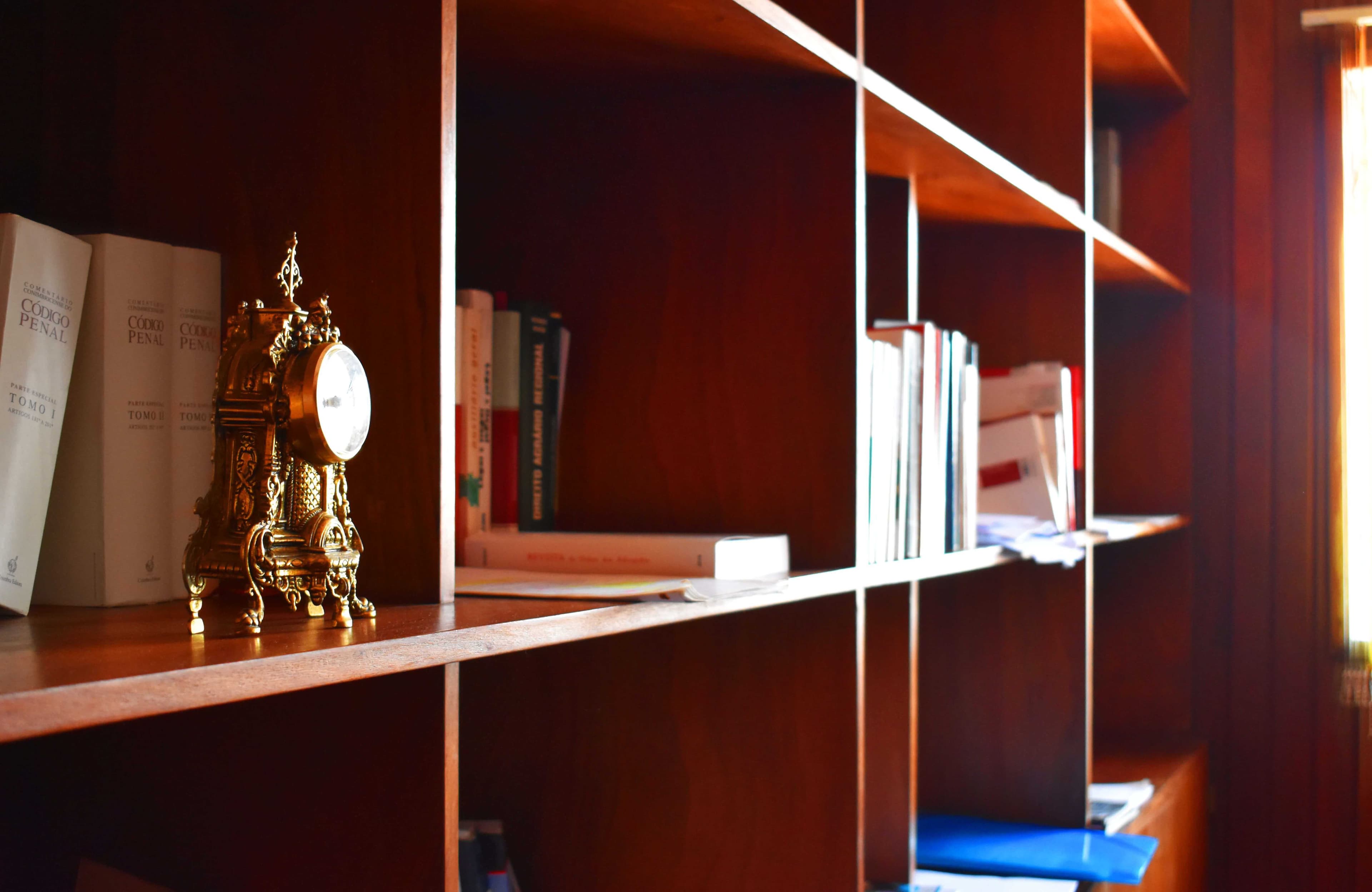 Pormenor da estante com relógio e livros de direito